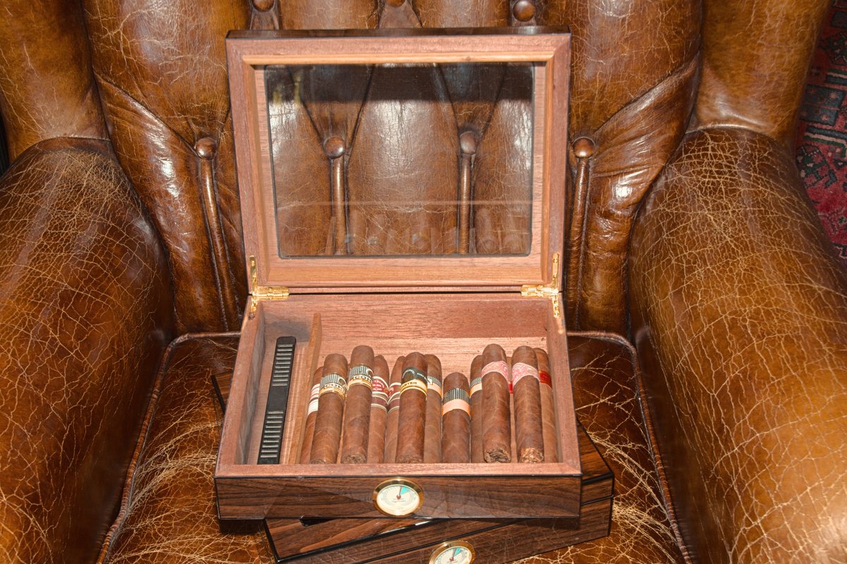 cigar humidor on a leather chesterfield chair.