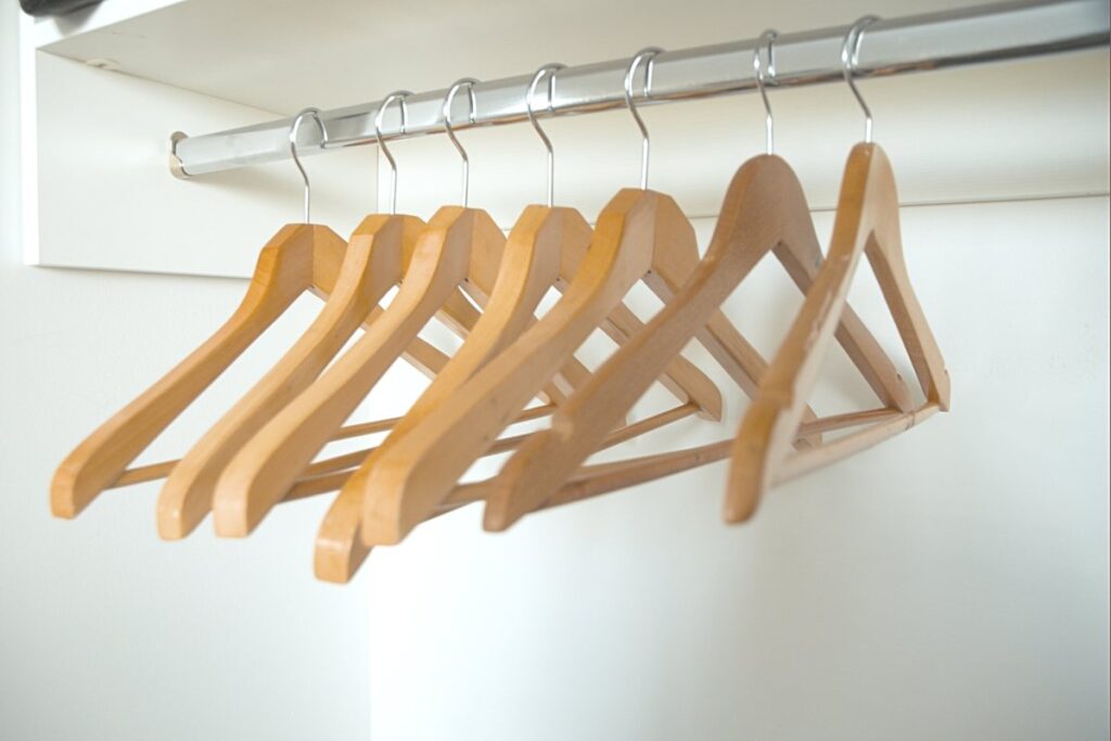 Matching wooden hangers on a wardrobe rail