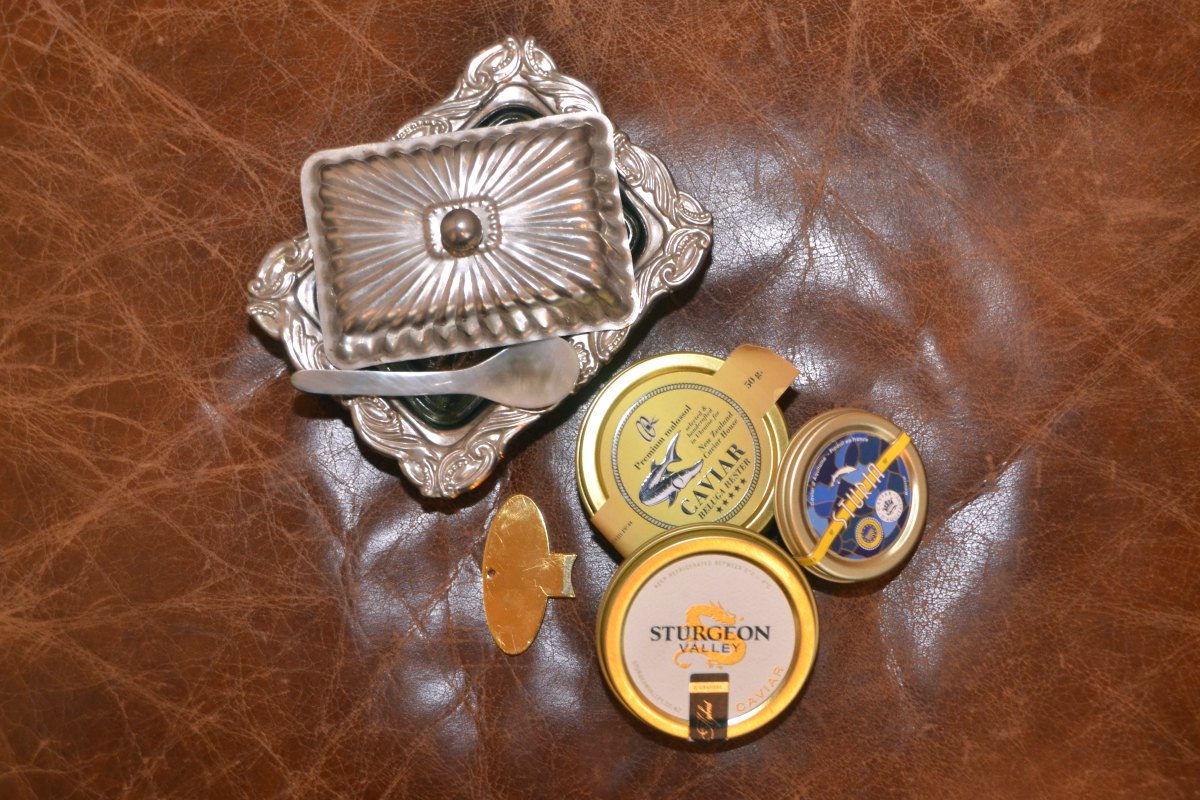Silver caviar dish with tins of caviar
