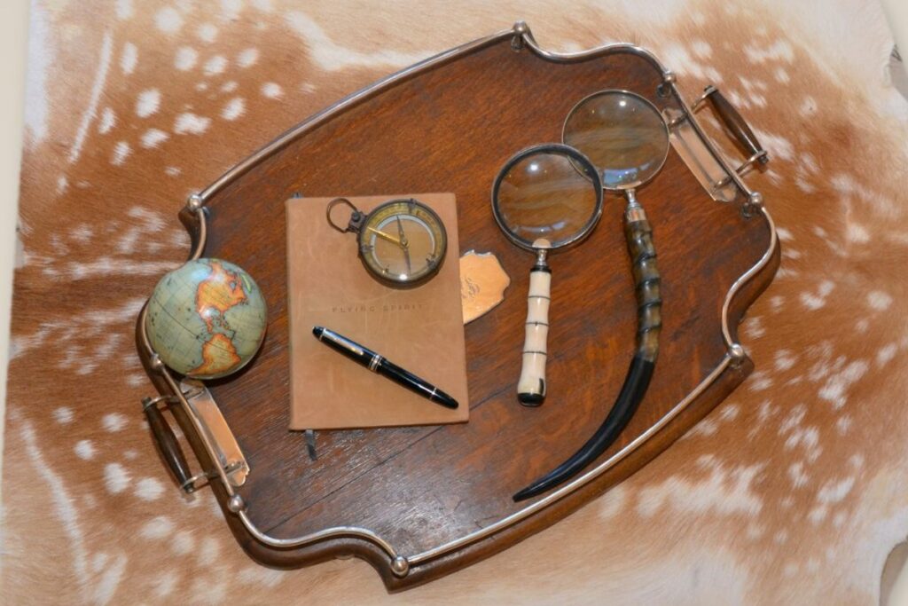 Antique tray with notebook, compass, magnifying glasses and small globe
